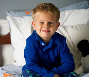 Boy Smiling on Bed