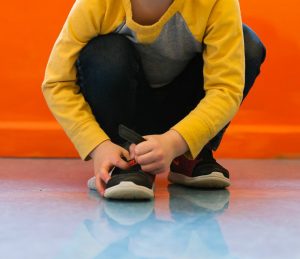 Boy putting shoes on
