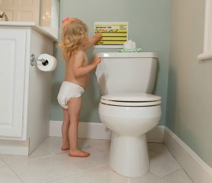 Girl putting sticker on potty training chart