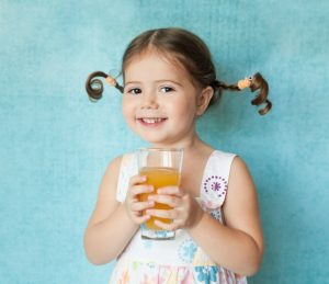Girl Holding Glass of Orange Juice